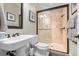 This bathroom features a tiled shower, pedestal sink, and framed mirror at 267 Osprey Hammock Trl, Sanford, FL 32771