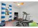 Bright bedroom with hardwood floors, ceiling fan, large windows, and exercise equipment at 267 Osprey Hammock Trl, Sanford, FL 32771