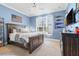This bedroom features a large bed, blue walls, shutters, and sports decor at 267 Osprey Hammock Trl, Sanford, FL 32771