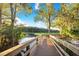 Community wooden dock extends over a lake, surrounded by trees and lily pads, offering a serene view at 267 Osprey Hammock Trl, Sanford, FL 32771