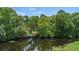 Waterfront dock offers picturesque views of the serene water surrounded by lush trees at 267 Osprey Hammock Trl, Sanford, FL 32771