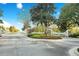Beautiful white entry gates to the community with manicured landscaping and stone pillars at 267 Osprey Hammock Trl, Sanford, FL 32771