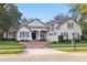 Elegant home with a red brick driveway, well manicured lawn, and a three car garage at 267 Osprey Hammock Trl, Sanford, FL 32771