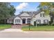 Charming home exterior features a brick driveway, lush landscaping, and classic architectural design at 267 Osprey Hammock Trl, Sanford, FL 32771