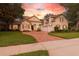 Stunning home exterior features brick driveway, well-maintained landscaping, and warm sunset hues at 267 Osprey Hammock Trl, Sanford, FL 32771