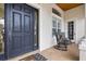 Covered front porch with tile flooring, a dark wood door, and rocking chairs at 267 Osprey Hammock Trl, Sanford, FL 32771