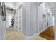 Well-lit hallway with tile flooring transitions to wood flooring; neutral colored walls, white trim at 267 Osprey Hammock Trl, Sanford, FL 32771