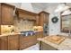 The kitchen has custom cabinets, stainless steel appliances, granite countertops, and a gas cooktop at 267 Osprey Hammock Trl, Sanford, FL 32771