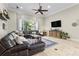 Living room with a tile floor, and a large dark leather sectional at 267 Osprey Hammock Trl, Sanford, FL 32771