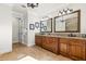 Bright bathroom with dual sinks, granite counters, decorative mirrors, and door to toilet at 267 Osprey Hammock Trl, Sanford, FL 32771