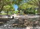 Neighborhood playground with mature trees, play equipment, and benches in a peaceful setting at 267 Osprey Hammock Trl, Sanford, FL 32771
