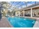 Screened pool featuring a spa, waterfalls, and an outdoor kitchen area at 267 Osprey Hammock Trl, Sanford, FL 32771