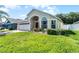 Single-story home with landscaped yard, brick paved driveway, and an attached two-car garage at 2729 Stanwood Dr, Kissimmee, FL 34743