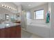 Bright main bathroom with large soaking tub, glass-enclosed shower, and granite countertop vanity at 2729 Stanwood Dr, Kissimmee, FL 34743