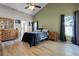 Well-lit main bedroom with ceiling fan, wood-look floors, large window and wooden dresser at 2729 Stanwood Dr, Kissimmee, FL 34743