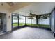 Relaxing screened-in patio features tile flooring, ceiling fan, and views of the fenced backyard at 2729 Stanwood Dr, Kissimmee, FL 34743