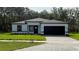 Charming single story home with black trim, a well-manicured lawn, and a paved driveway at 285 Marion Oaks Crse, Ocala, FL 34473