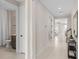 Bright hallway with tile flooring leads to various rooms, including a bathroom at 3373 Orange Rose Loop, Apopka, FL 32712