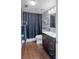 Cozy bathroom featuring a dark shower curtain, modern fixtures, and wood-look flooring at 400 E Colonial Dr # 207, Orlando, FL 32803