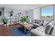 The living room features a comfortable sofa, large windows, and a cozy blue rug at 400 E Colonial Dr # 207, Orlando, FL 32803