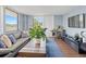 A spacious living room with large windows and a neutral-colored sofa and blue rug at 400 E Colonial Dr # 207, Orlando, FL 32803