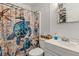 The bathroom featuring a decorative shower curtain, white sink, and storage at 405 Willow Ave, Sanford, FL 32771