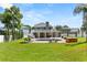 Grassy backyard featuring a pool, hot tub, outdoor seating, and a second story balcony at 4065 Shadowind Way, Gotha, FL 34734