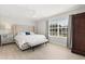 Comfortable bedroom with a plush bed, side table, and a large window, creating a relaxing ambiance at 4065 Shadowind Way, Gotha, FL 34734