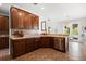 Open kitchen with stainless steel dishwasher, wooden cabinetry, and neutral countertops and backsplash at 4065 Shadowind Way, Gotha, FL 34734