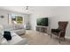The living room features a white couch, ceiling fan, modern decor, and natural light from the window at 4065 Shadowind Way, Gotha, FL 34734