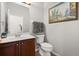 Powder room with dark wood cabinet, a modern white toilet and paint detail with an ornate painting at 4065 Shadowind Way, Gotha, FL 34734