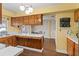 Open kitchen with wood cabinets, tile countertops, stainless steel appliances, and connection to the dining area at 407 Westchester Dr, Altamonte Springs, FL 32701