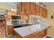 Well-lit kitchen featuring wood cabinets, tile countertops, stainless steel appliances, and a breakfast bar at 407 Westchester Dr, Altamonte Springs, FL 32701