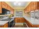 Bright kitchen featuring wood cabinets, tile countertops, stainless steel appliances, and a window with a backyard view at 407 Westchester Dr, Altamonte Springs, FL 32701