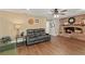 Inviting living room features a cozy brick fireplace, wood floors, and comfortable black sofa set at 407 Westchester Dr, Altamonte Springs, FL 32701