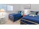 A bedroom featuring twin beds, blue bedding, and decorative accents that create a cozy atmosphere at 4153 S Atlantic Ave # 2120, New Smyrna Beach, FL 32169