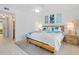 Bright bedroom featuring tropical-themed bedding and wall art and an adjoining entryway at 4153 S Atlantic Ave # 2120, New Smyrna Beach, FL 32169