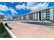 A multi-story condominium with a blue exterior, features a shuffleboard court and an outdoor pool at 4153 S Atlantic Ave # 2120, New Smyrna Beach, FL 32169