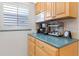 Cozy kitchen counter with a coffee station, light wood cabinetry, and stylish countertop accessories at 4153 S Atlantic Ave # 2120, New Smyrna Beach, FL 32169