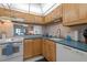 Bright kitchen featuring wood cabinets, blue countertops, and a window with a view of the living room at 4153 S Atlantic Ave # 2120, New Smyrna Beach, FL 32169
