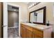 Well-lit bathroom featuring wood cabinetry, large mirror, and neutral countertop at 500 W Oakland Ave, Oakland, FL 34760