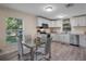 Bright kitchen boasts white cabinets, modern appliances, and a dining area with hardwood floors at 500 W Oakland Ave, Oakland, FL 34760