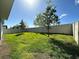Spacious fenced-in backyard with green grass and some trees at 605 Big Pine Ave, Minneola, FL 34715