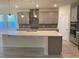 Bright and open kitchen showcasing pendant lighting, gray cabinets, and a large center island with seating at 605 Big Pine Ave, Minneola, FL 34715
