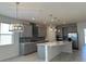 Open-concept kitchen with gray cabinets, stainless steel appliances, and an oversized kitchen island at 605 Big Pine Ave, Minneola, FL 34715