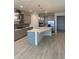 Open kitchen featuring gray cabinets, modern stainless steel appliances, and a large center island at 605 Big Pine Ave, Minneola, FL 34715