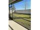 The screened-in porch offers views of the well-kept lawn, fence, and trees at 605 Big Pine Ave, Minneola, FL 34715