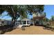 Exterior of home features a large backyard with mature trees, a treehouse, and seating at 6428 Lynn Rd, Orlando, FL 32810