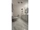 Bright bathroom with marble floors, white vanity, floating shelves, and modern fixtures at 6428 Lynn Rd, Orlando, FL 32810