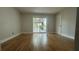 Bright bedroom featuring wood flooring, a door, and sliding glass doors leading to a balcony at 6428 Lynn Rd, Orlando, FL 32810
